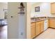 Galley kitchen with wood cabinets, a double sink, and a white dishwasher at 3050 Pirates Retreat Ct # 402, Kissimmee, FL 34747