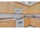 Bright kitchen features wooden cabinets, an electric range, microwave, and stone-look countertops at 3050 Pirates Retreat Ct # 402, Kissimmee, FL 34747