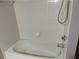 Clean white bathtub and shower with white tile walls and silver hardware at 3561 Conroy Rd # 214, Orlando, FL 32839