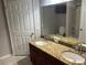 Bathroom featuring a double sink vanity with granite countertop, tile floor, and white door at 3561 Conroy Rd # 214, Orlando, FL 32839