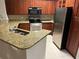 Kitchen showcasing granite counters, stainless steel appliances, and wood cabinets at 3561 Conroy Rd # 214, Orlando, FL 32839