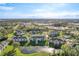 A scenic aerial view shows several three-story condo buildings with a lake, lawns, mature trees, and a pool at 4280 Summer Landing Dr # 204, Lakeland, FL 33810