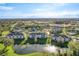 A scenic aerial view shows several three-story condo buildings with a lake, lawns, and mature trees at 4280 Summer Landing Dr # 204, Lakeland, FL 33810