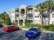 A three-story condo building painted in light colors with palm trees and manicured shrubs in front at 4280 Summer Landing Dr # 204, Lakeland, FL 33810