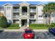 A three-story condo building painted in light colors with palm trees and manicured shrubs in front at 4280 Summer Landing Dr # 204, Lakeland, FL 33810