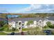 A beautiful, spacious, light-colored condo building with three stories is near a lake and has well-manicured lawns at 4280 Summer Landing Dr # 204, Lakeland, FL 33810