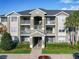 A three-story condo building painted in light colors with palm trees and manicured shrubs in front at 4280 Summer Landing Dr # 204, Lakeland, FL 33810
