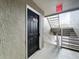 Hallway and unit entry featuring staircase and a black apartment entry door at 4280 Summer Landing Dr # 204, Lakeland, FL 33810