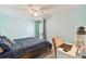 This bedroom features soft blue walls, a ceiling fan, and a convenient desk area at 4353 Shadow Crest Pl # 3, Orlando, FL 32811
