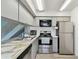 Well-lit kitchen with stainless steel appliances, light gray cabinets, and sleek countertops at 4353 Shadow Crest Pl # 3, Orlando, FL 32811