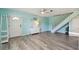 Bright living room featuring modern flooring, a staircase, and an entry door at 4353 Shadow Crest Pl # 3, Orlando, FL 32811