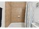 A tiled shower/tub combo featuring a curved shower curtain rod, a shelf and wall soap dish at 4353 Shadow Crest Pl # 3, Orlando, FL 32811