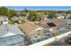 Aerial view of a home showcasing a screened-in pool and neighborhood in a sunny location at 458 Hollinghead Loop, Davenport, FL 33896