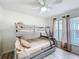 Bunk bed bedroom featuring a ceiling fan, wooden floor, and a large window at 458 Hollinghead Loop, Davenport, FL 33896