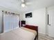 Well-lit bedroom with a ceiling fan, TV, and a sliding glass door at 458 Hollinghead Loop, Davenport, FL 33896