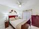 Cozy bedroom with cherry wood furniture, a ceiling fan and a light wooden floor at 458 Hollinghead Loop, Davenport, FL 33896