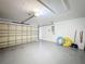 Spacious garage featuring an automatic door, gray floor and white walls providing ample storage and parking space at 458 Hollinghead Loop, Davenport, FL 33896