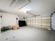 Well-lit garage with an automatic door, shelving, and painted concrete floor perfect for storage and projects at 458 Hollinghead Loop, Davenport, FL 33896