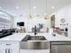 Bright, modern kitchen with stainless steel sink, white countertops, and open floor plan at 458 Hollinghead Loop, Davenport, FL 33896
