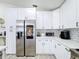 Kitchen featuring stainless steel appliances, white cabinets, and lots of counter space at 458 Hollinghead Loop, Davenport, FL 33896