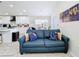 Bright living room showcasing a comfortable blue sofa and an open floorplan to the kitchen at 458 Hollinghead Loop, Davenport, FL 33896