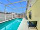 Inviting screened-in pool area with lounge chairs offering a perfect outdoor relaxation space at 458 Hollinghead Loop, Davenport, FL 33896