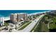 Stunning aerial view of a beachfront condo building, highlighting its proximity to the ocean, golf course, and surrounding homes at 4651 S Atlantic Ave # 2030, Ponce Inlet, FL 32127