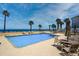 Community swimming pool with chairs and tables to relax by the water at 4651 S Atlantic Ave # 2030, Ponce Inlet, FL 32127
