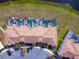 Aerial image shows condo building with private pools, tile roofs, parking, and view of a pond and landscaping at 4841 Romeo Cir, Kissimmee, FL 34746