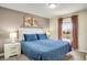 Comfortable bedroom featuring blue bedding and a bright window view at 4841 Romeo Cir, Kissimmee, FL 34746
