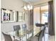 Elegant dining room featuring a glass-top table, modern chandelier, and a mirrored wall at 4841 Romeo Cir, Kissimmee, FL 34746