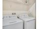 Laundry room with white washer, dryer, and storage shelf at 4841 Romeo Cir, Kissimmee, FL 34746