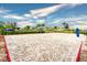 Outdoor sand volleyball court with blue skies and palm trees in a resort community at 4841 Romeo Cir, Kissimmee, FL 34746