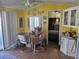 Bright dining area with yellow walls, laminate floors, and adjacent to a cozy bedroom at 50989 Highway 27 # 130, Davenport, FL 33897