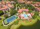Aerial view of a community featuring a pool, tennis courts, a lake and multiple buildings at 528 Lobelia Dr, Lake Mary, FL 32746