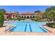 Community pool with clear blue water, brick patio, lounge chairs, and tropical landscaping at 528 Lobelia Dr, Lake Mary, FL 32746