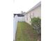 Narrow backyard with white picket fence, green grass, and some small bushes at 536 Dunoon St, Ocoee, FL 34761