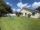 Spacious backyard with green lawn, swing set, and a classic white fence outlining the property at 536 Dunoon St, Ocoee, FL 34761