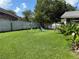 Green backyard featuring playset, green grass, and white fence at 536 Dunoon St, Ocoee, FL 34761