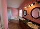 Bathroom featuring a corner tub, double sinks, and oval mirrors above the vanity at 536 Dunoon St, Ocoee, FL 34761