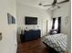 Comfortable bedroom with a ceiling fan, wall-mounted TV, dresser, and closet at 536 Dunoon St, Ocoee, FL 34761
