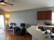 This living space has a ceiling fan, a desk, a grey recliner, and access to the kitchen at 536 Dunoon St, Ocoee, FL 34761