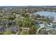 Panoramic aerial view of the neighborhood with lake access, homes nestled among trees, and city skyline at 5569 Jessamine Ln, Orlando, FL 32839