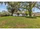 Lush backyard featuring a well-maintained lawn and mature trees, creating a private outdoor space at 5569 Jessamine Ln, Orlando, FL 32839