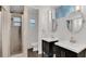 Bathroom with dual dark-wood vanities, oval mirrors, and a glass-enclosed shower at 5569 Jessamine Ln, Orlando, FL 32839