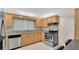 Galley kitchen features stainless steel appliances, stone countertops, and light colored wooden cabinetry at 5569 Jessamine Ln, Orlando, FL 32839