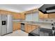 Bright kitchen with stainless steel appliances, light wood cabinetry, and a stone tile backsplash at 5569 Jessamine Ln, Orlando, FL 32839