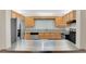 Classic kitchen features stainless steel appliances, stainless sink, light wood cabinets and a countertop bar at 5569 Jessamine Ln, Orlando, FL 32839