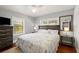 Cozy bedroom showcasing a ceiling fan, a large bed, and two windows that flood the room with natural light at 7 Clarendon Ct, Daytona Beach, FL 32118