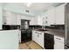 Well-appointed kitchen with white cabinets, black appliances, and modern backsplash at 7 Clarendon Ct, Daytona Beach, FL 32118